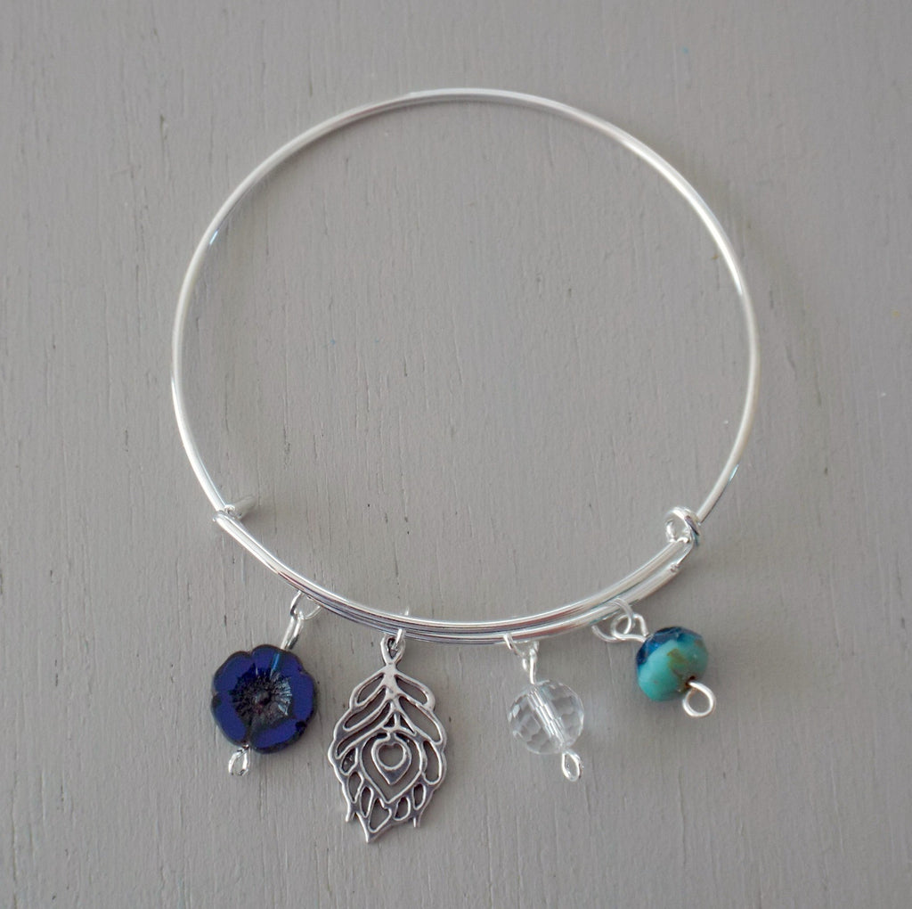 Adjustable bangle with silver plated peacock feather charm, blue / green beads