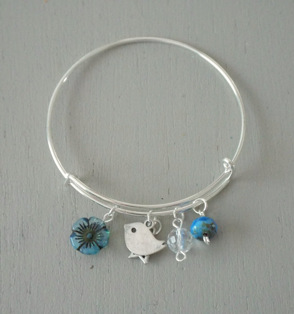 Adjustable silver plated bangle, bird & star charms, blue accents